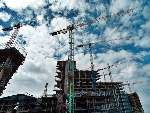 a new apartment building being built by large cranes